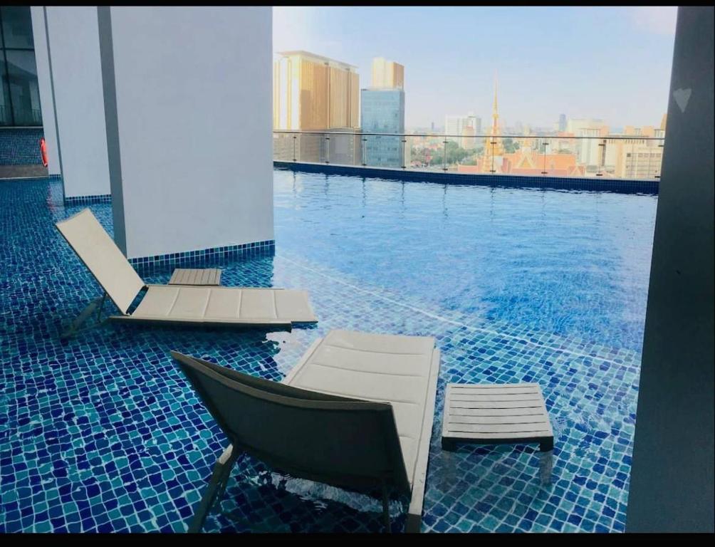 a swimming pool with a lounge chair and a swimming pool at ImPian 1BR condo in Phnom Penh