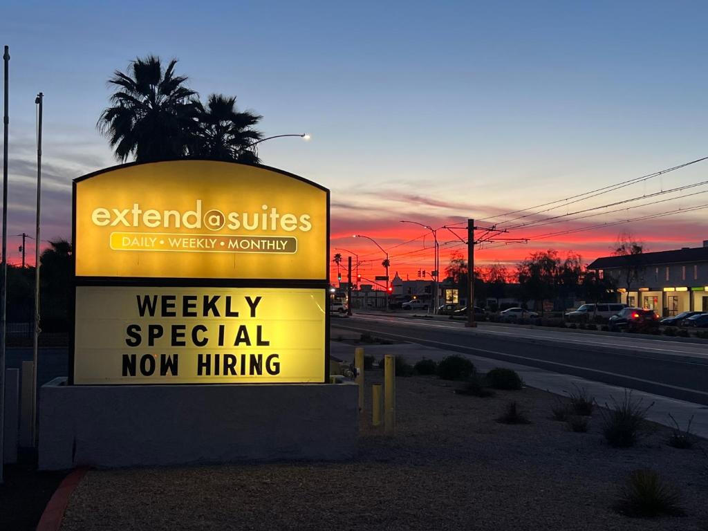 a sign for aweekly special non hiring on a road at Extend -a -Suites Mesa in Mesa