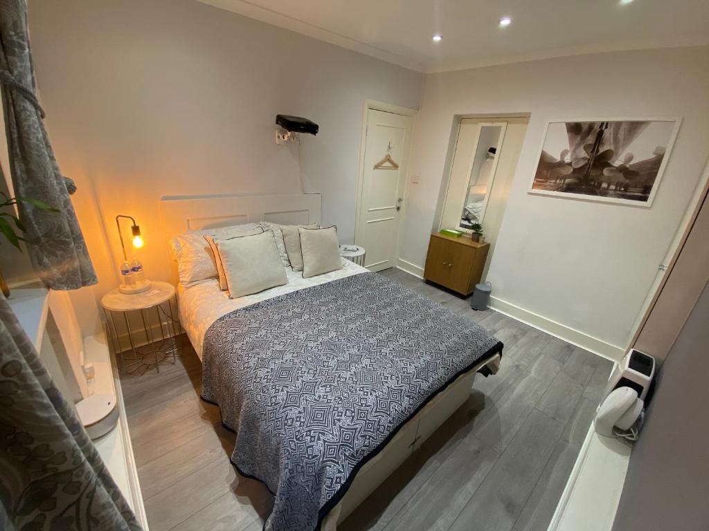 a small bedroom with a bed and a lamp at Central Private Double Bedroom in a 2bedroom Apartment, connected via underground, overground and many bus routes in London