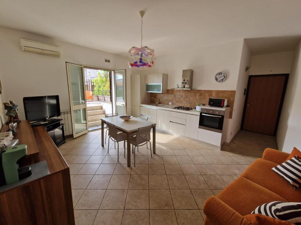 a kitchen and living room with a table and a couch at A&M Home in Letojanni