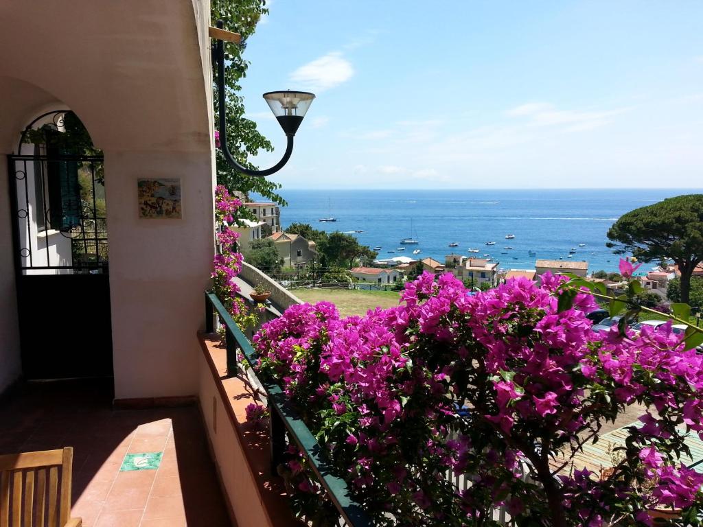 un balcón con flores púrpuras y vistas al océano. en Casa Vacanze Bouganvillea, en Cetara