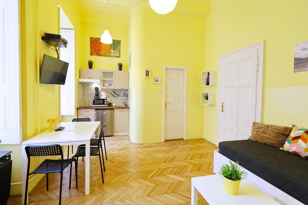 een gele woonkamer met een tafel en een bank bij Supreme Astoria Semmelweis in Boedapest