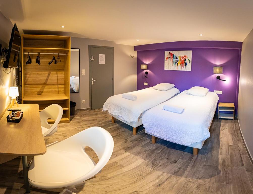 um quarto com duas camas e uma mesa e cadeiras em Résidence Artemis Paris Orly Aéroport em Villeneuve-le-Roi