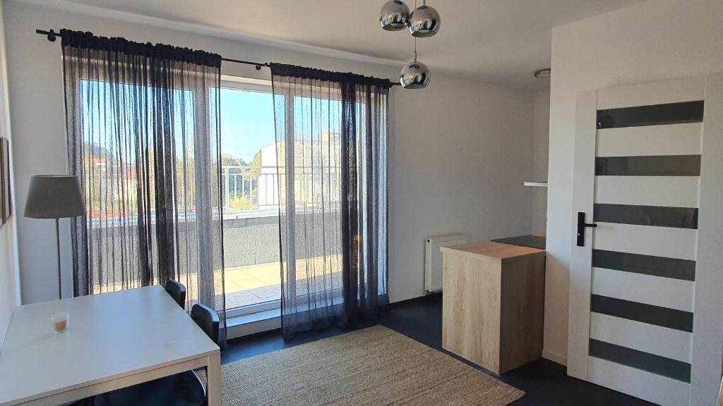 an empty room with a large window with a view at Apartament przy centrum in Koszalin