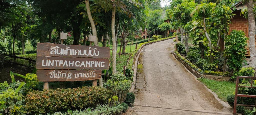 um sinal para uma entrada para um parque com uma estrada em ลิ้นฟ้าแคมปิ้งรีสอร์ท em Mae Hong Son