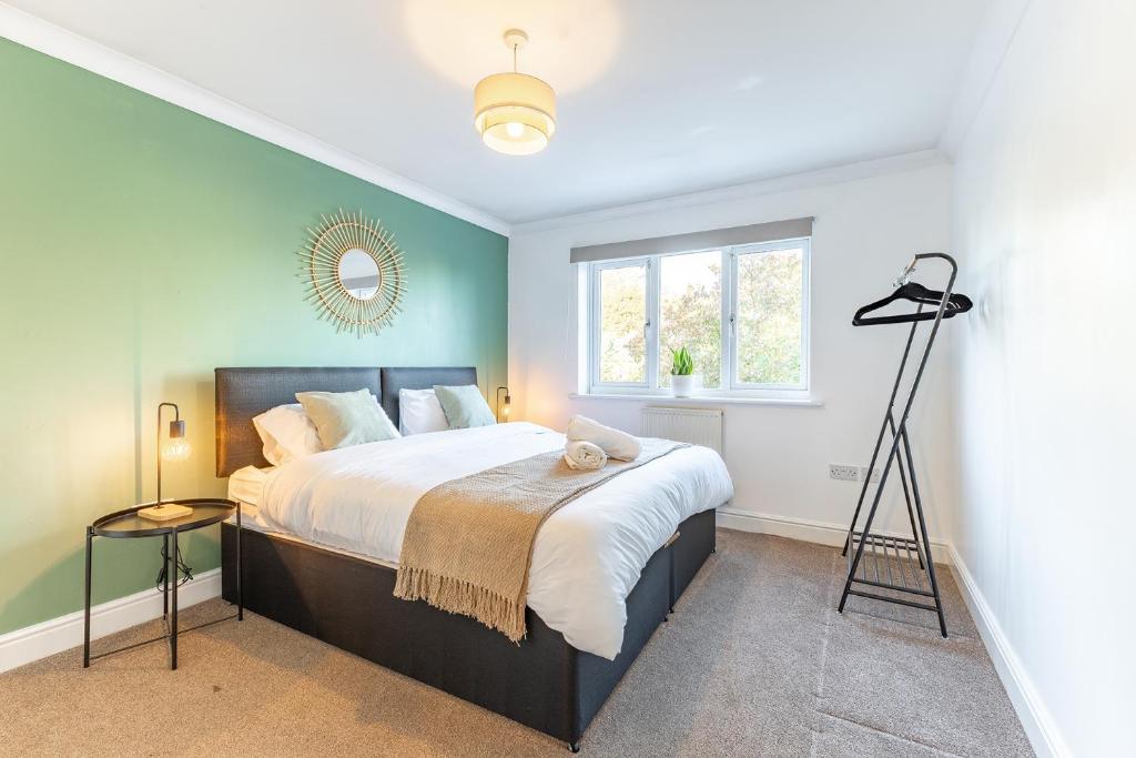 a bedroom with a large bed and a window at 5 Bed House Heathrow Egham Virginia Water Sleeps 7 or 8 sharing in Egham