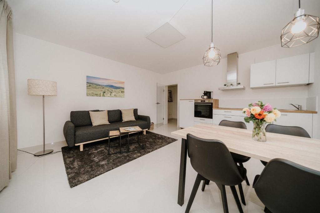 a kitchen and living room with a table and chairs at Ferienwohnung am Weinberg in Bötzingen