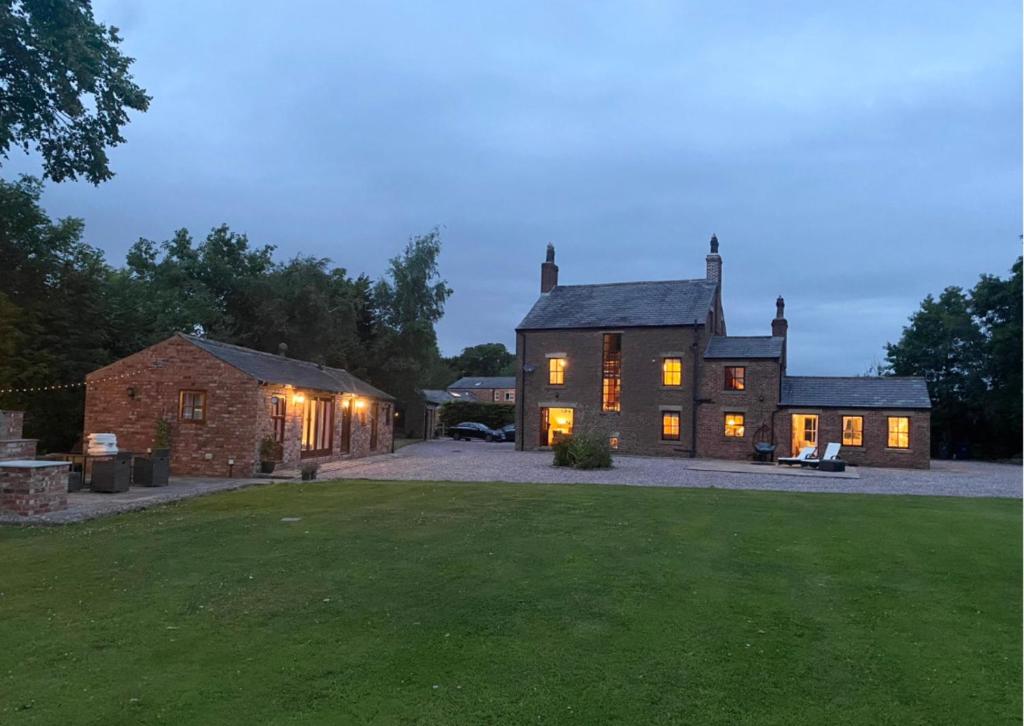 a large house with lights on in the yard at Manor House Farm 