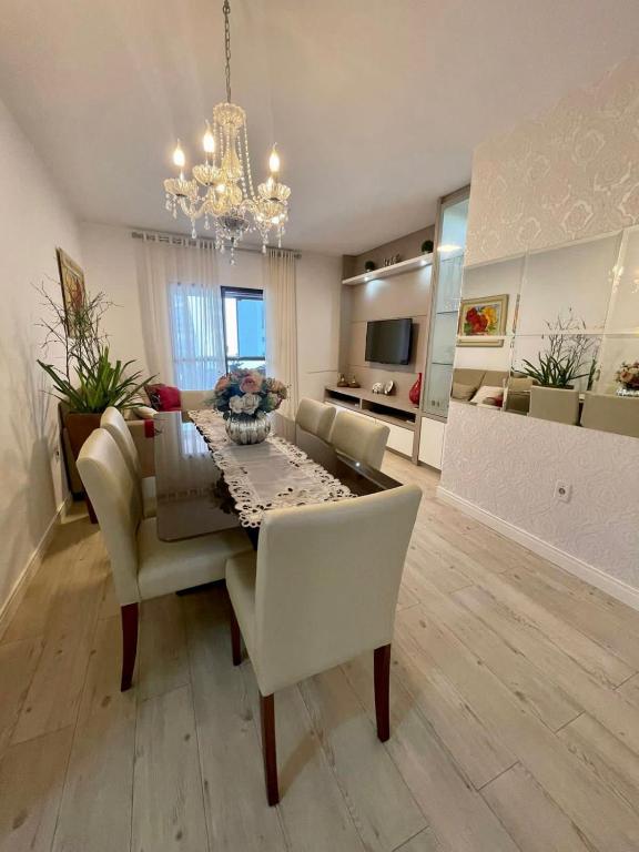 Un comedor y una sala de estar con mesa y sillas. en Apto 3 dorm completo - 100m Praia - Meia Praia, en Itapema