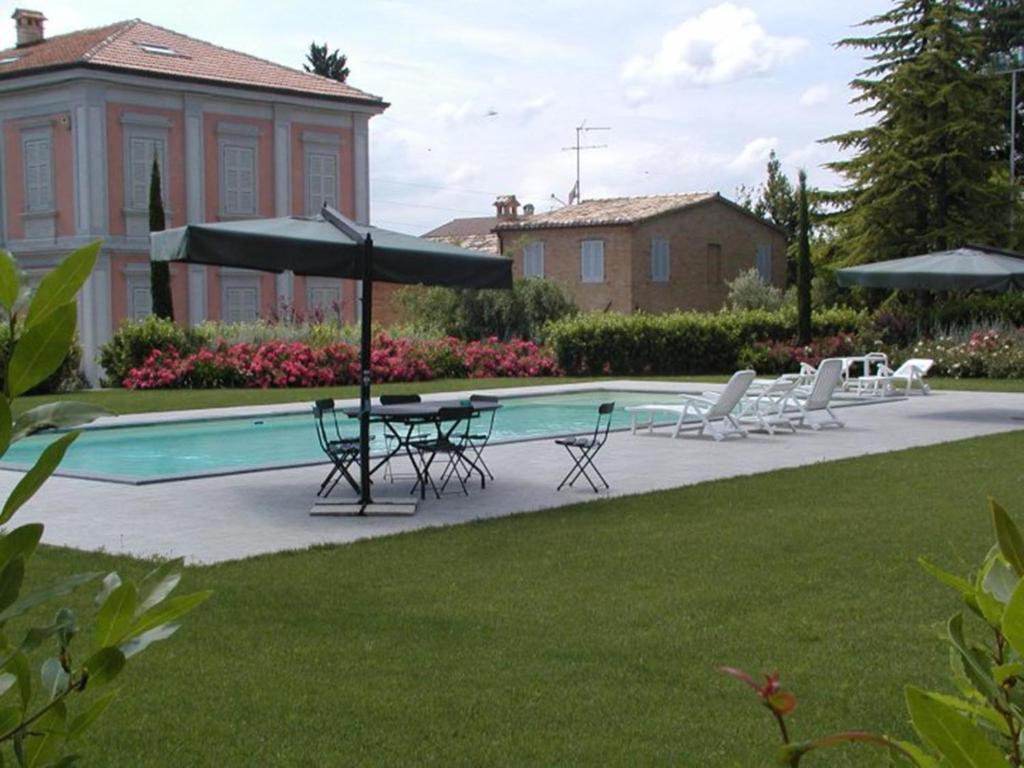 a patio with a table and chairs next to a pool at Borgo Sorbatti in Loro Piceno