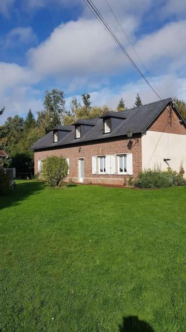 une maison dans une cour avec une pelouse verte dans l'établissement Maison 8-10 personnes, à Vrocourt