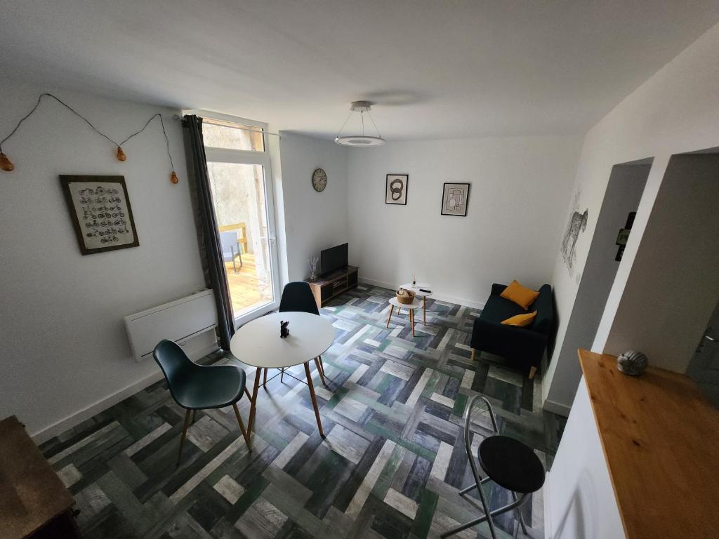 ein Wohnzimmer mit einem Tisch und Stühlen in der Unterkunft T2 jardin Guéret in Guéret