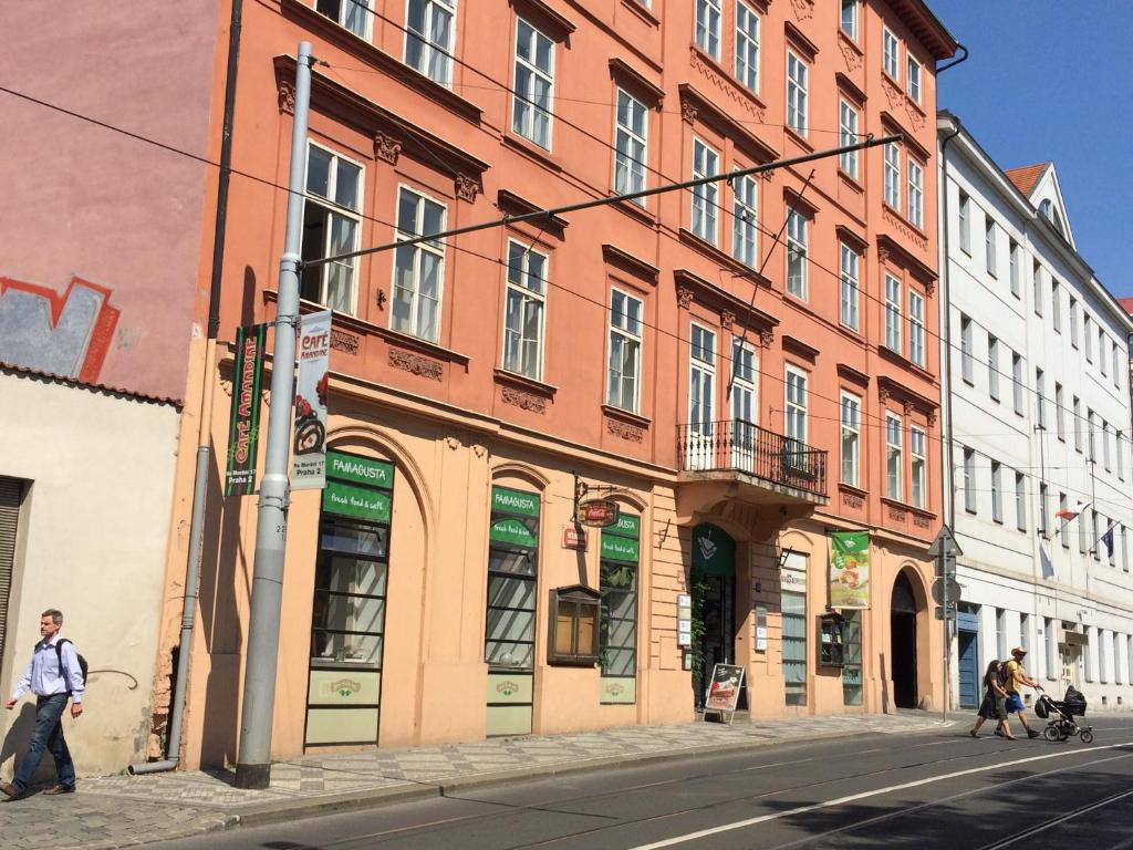 um grupo de pessoas andando por uma rua em frente a um edifício em Charles Square Hostel em Praga