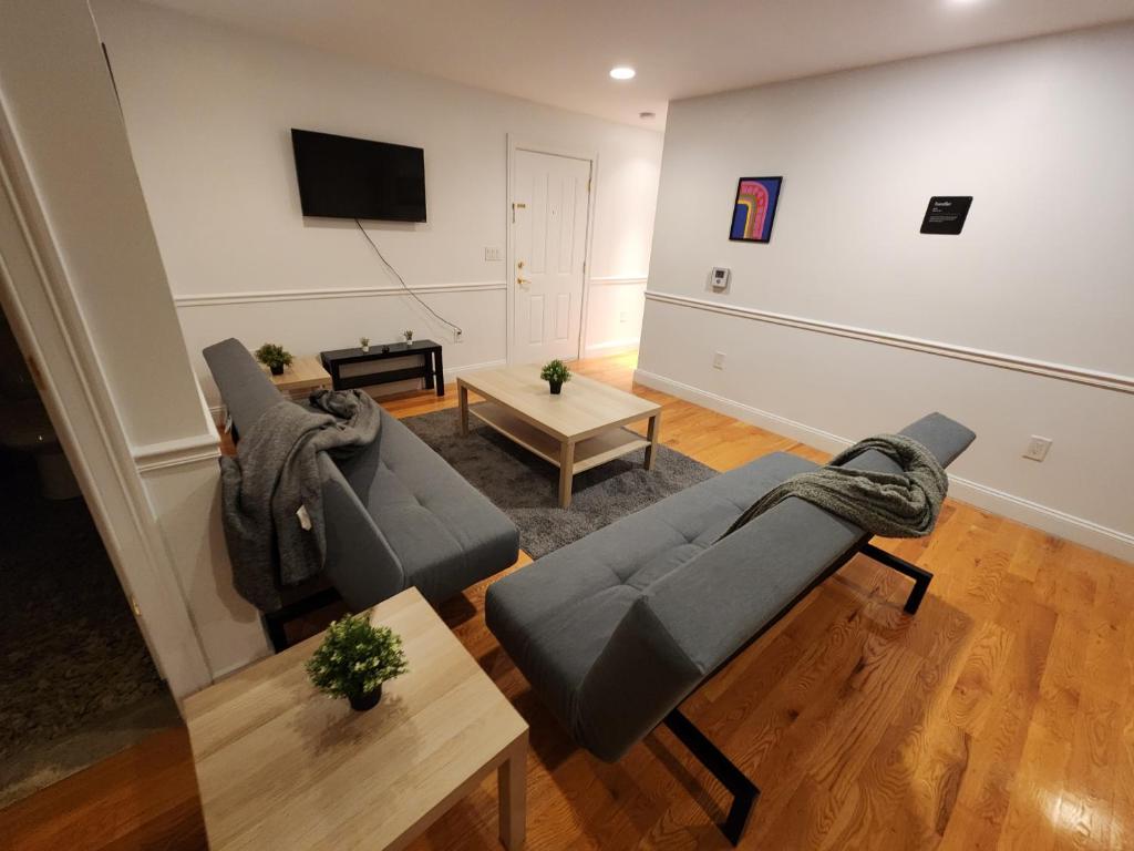 a living room with two couches and a tv at Stylish 2BR Apt Mins to NYC! in Union City