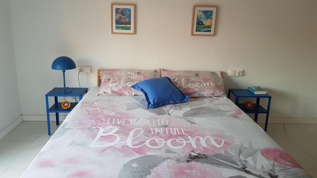 a bedroom with a bed with a bedspread that says ive you lie in at Sweet flat in Tortosa in Tortosa