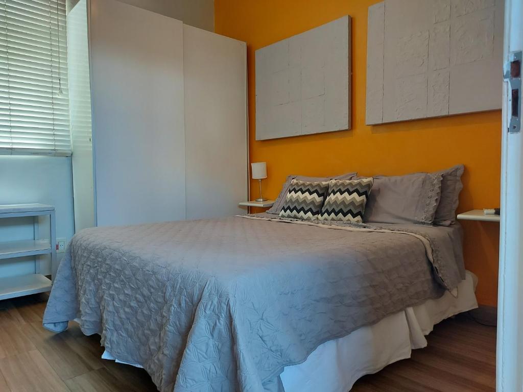 um quarto com uma cama com uma parede laranja em Alberto de Campos 66 no Rio de Janeiro