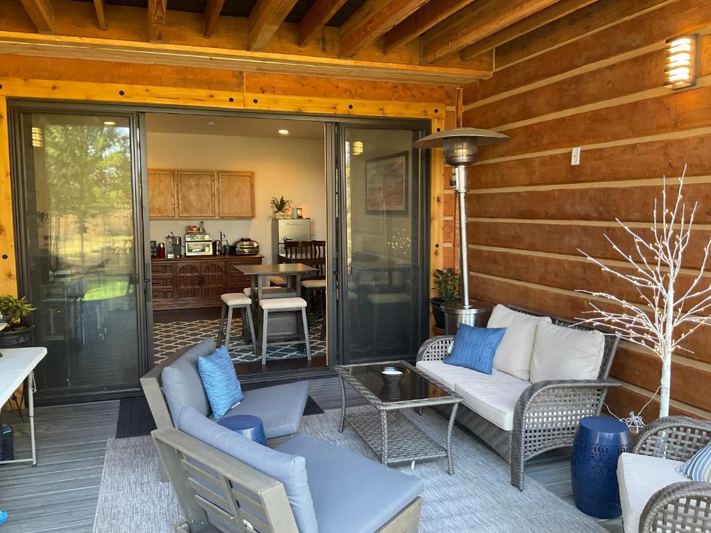 a screened in porch with furniture and a kitchen at Beautiful Riverfront Near Mt Bachelor with Hot Tub in Bend