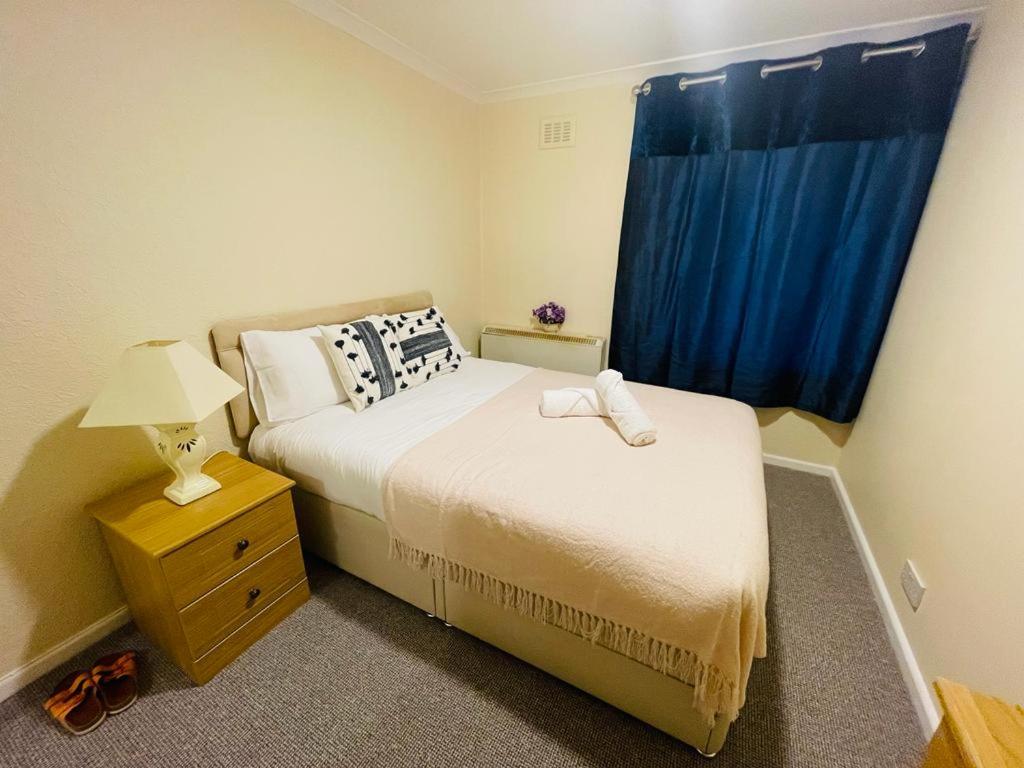 1 dormitorio con 2 camas y una ventana azul en Cosy flat en Little Paxton
