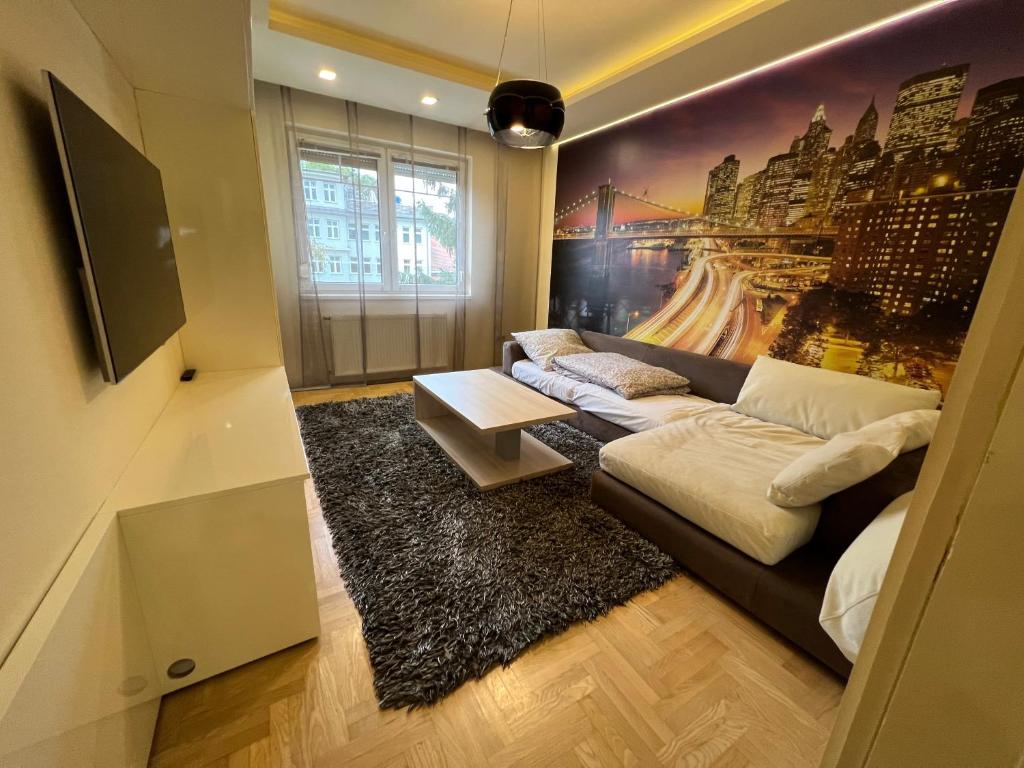 a living room with a couch and a painting on the wall at City Lux Apartman in Nyíregyháza