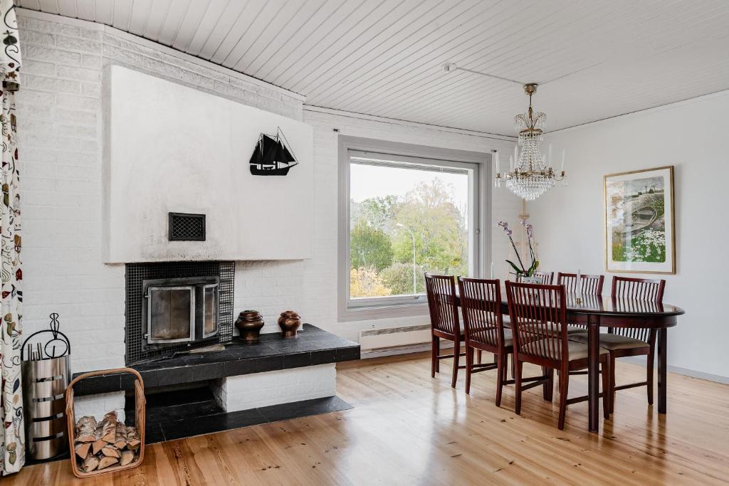 a dining room with a table and a fireplace at Large family home by the water in Östhammar