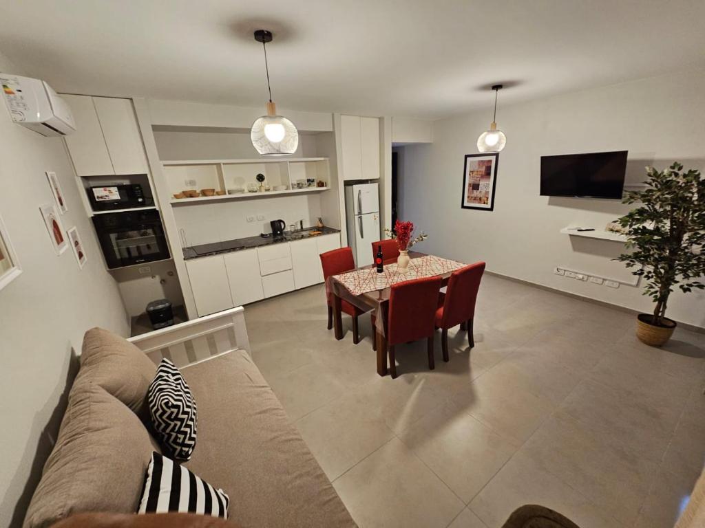 Una sala de estar y una cocina con mesa y sillas. en Riparo Bosques, en Maipú
