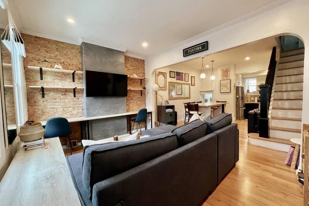a living room with a large couch and a dining room at Perfect WFH Fishtown Townhouse with Private Patio in Philadelphia