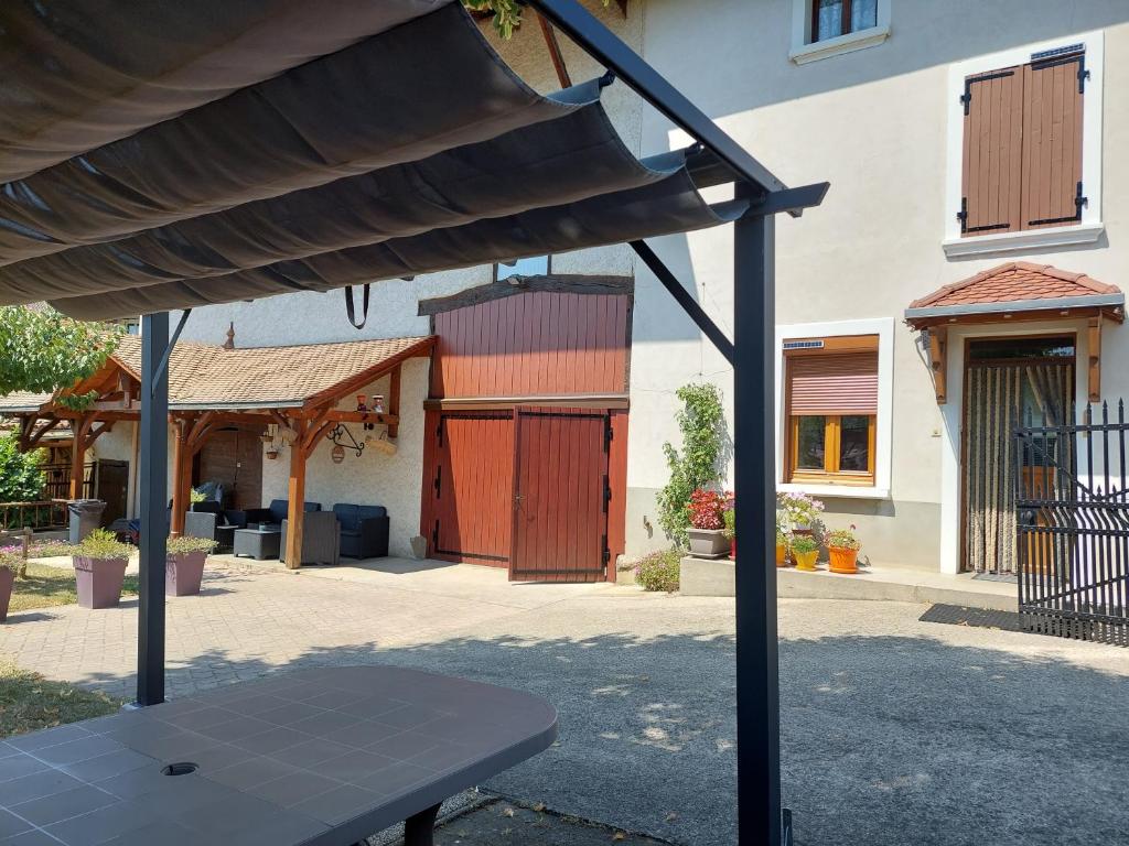 a patio with a table in front of a building at Les Copains d'Abord in Beaucroissant