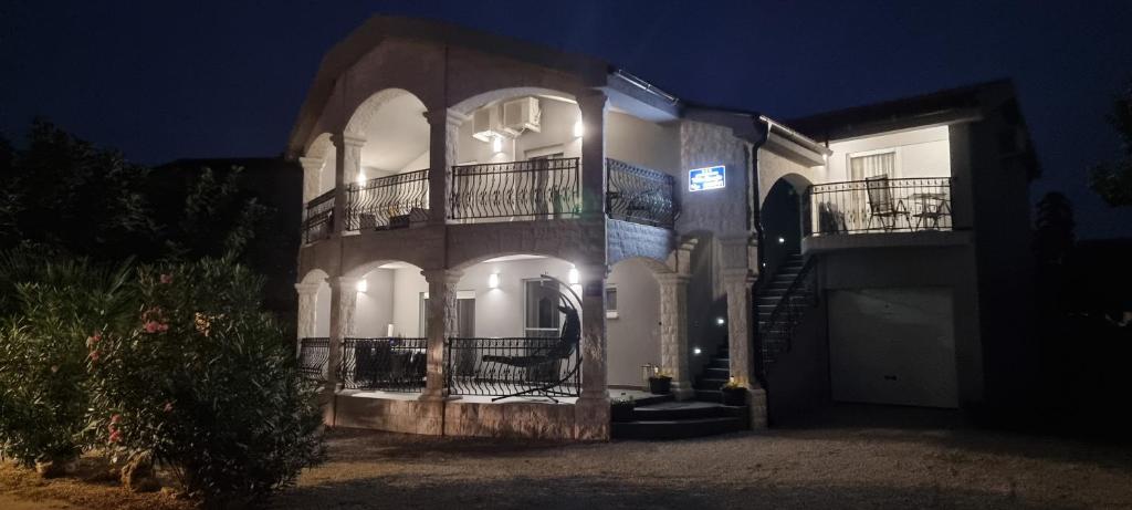 a large building with a balcony at night at Villa Marija in Vir