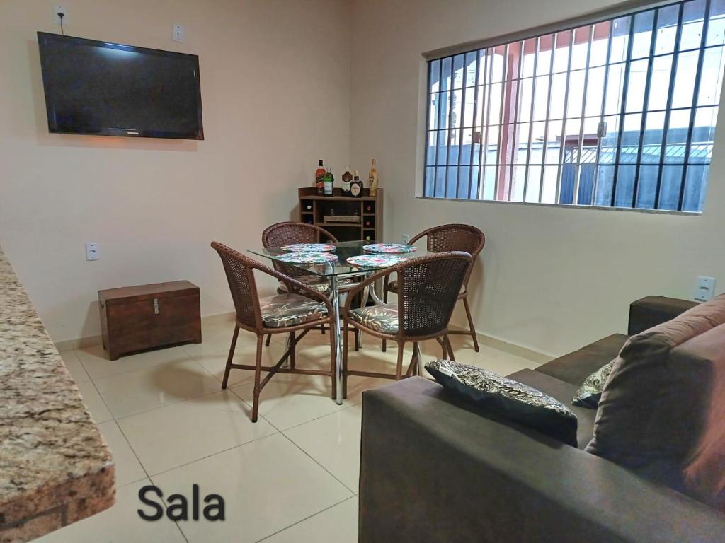 ein Wohnzimmer mit einem Tisch und Stühlen sowie einem TV in der Unterkunft CASA DE TEMPORADA DE FÉRIAS in Santa Cruz Cabrália
