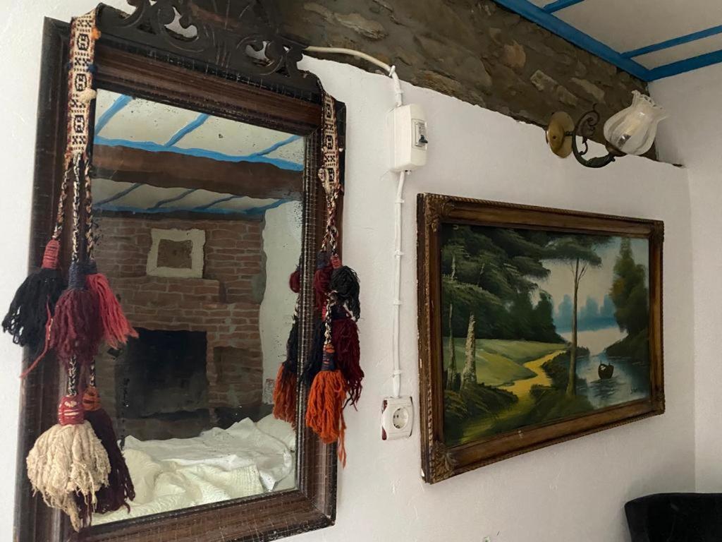 um espelho pendurado numa parede ao lado de um quadro em Şirince leylak ev pansiyon em Selçuk