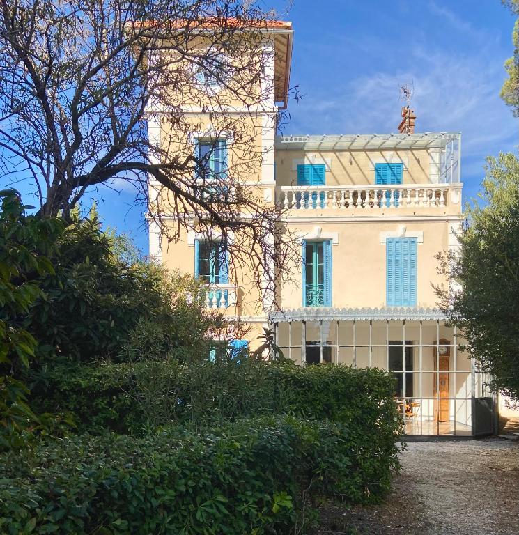 un grand bâtiment blanc avec une tour au sommet dans l'établissement Villa Jacqueline, à La Seyne-sur-Mer
