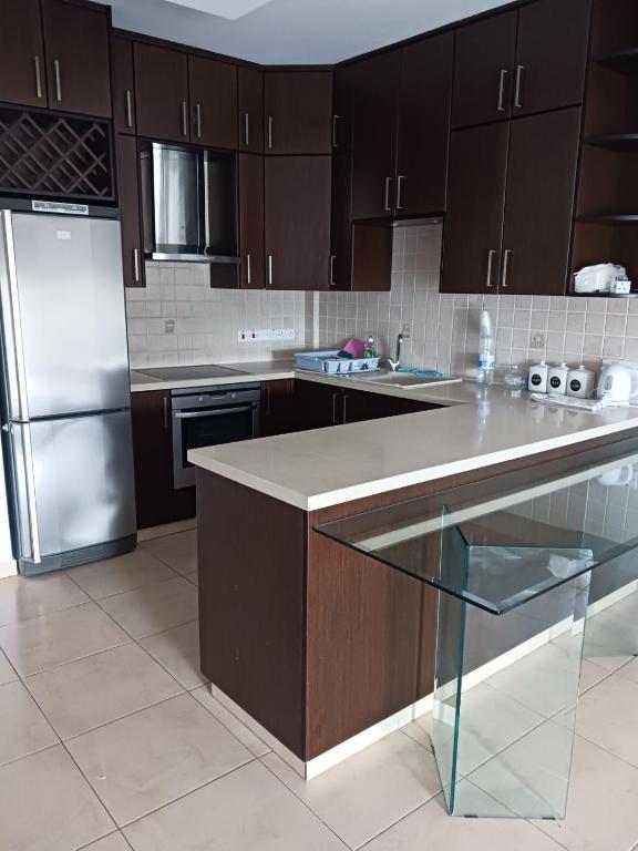 a kitchen with brown cabinets and a stainless steel refrigerator at 2 bedroom apartment in Nicosia