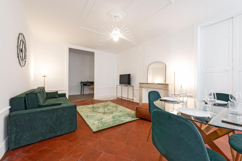 un salon avec un canapé vert et une table dans l'établissement Le Louis XVI - Majestueux Appart Centre Ville, à Carcassonne