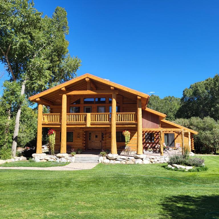 uma grande casa de madeira com um grande alpendre em BuffaloPeaks Lodge em Buena Vista