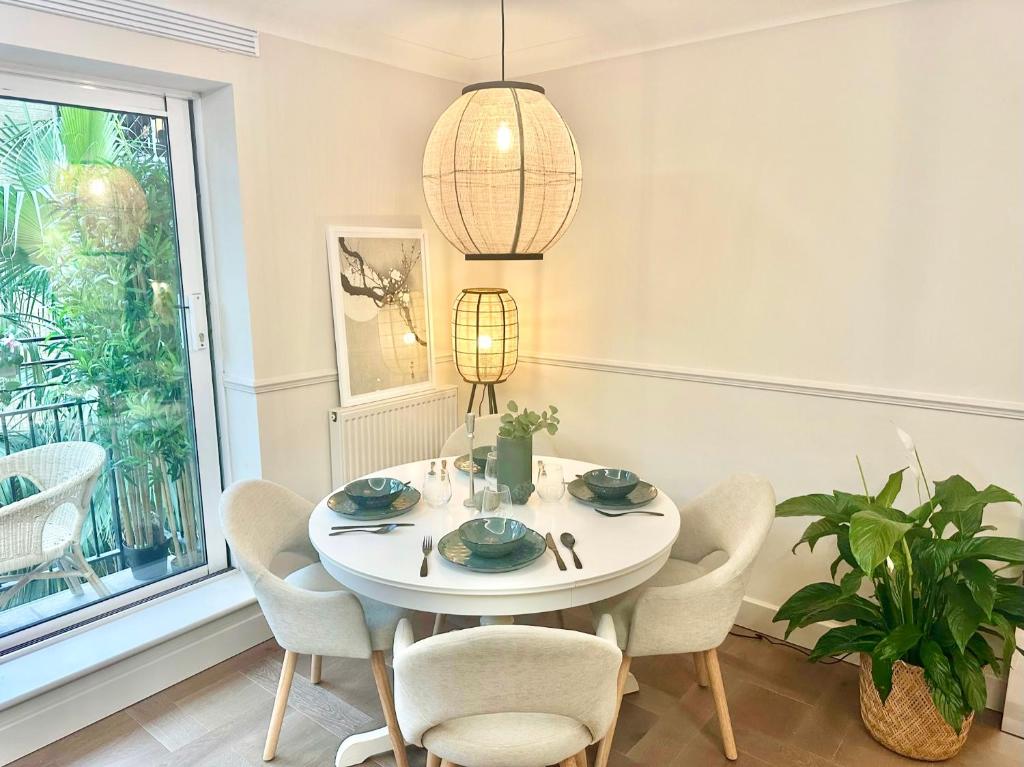 a white dining room with a white table and chairs at Tranquil 2 bedroom Apartment Close to St. Paul's Cathedral in London