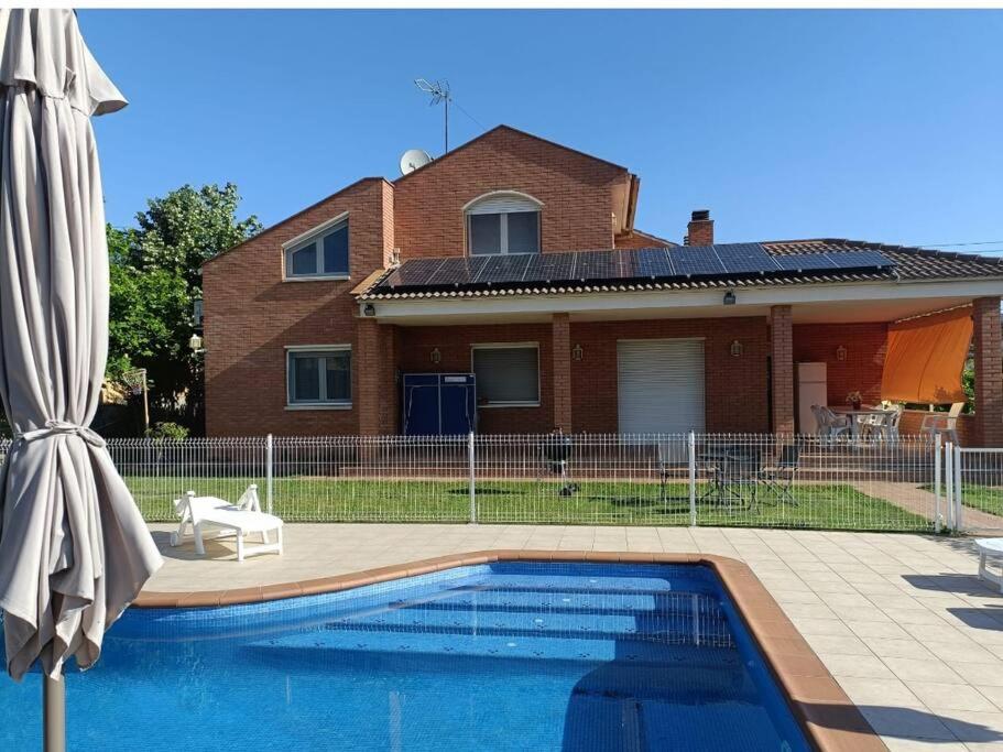 a house with a swimming pool in front of a house at Casa con jardín y piscina privada. in Santa Eulalia de Ronsaná