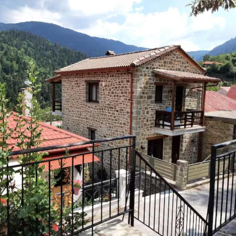 a house in the mountains with a balcony at Fairytale Stone House in Karpenisi
