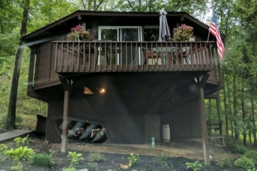 una casa en el árbol con una terraza encima en Round Cabin - 5 Min to Bedford PA - Deck - Hike- Golf, en Bedford