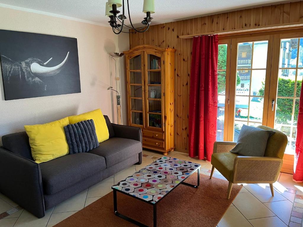 ein Wohnzimmer mit einem Sofa und einem Couchtisch in der Unterkunft L'Hérensarde, bel appartement avec jardin-terrasse et garage in Evolène