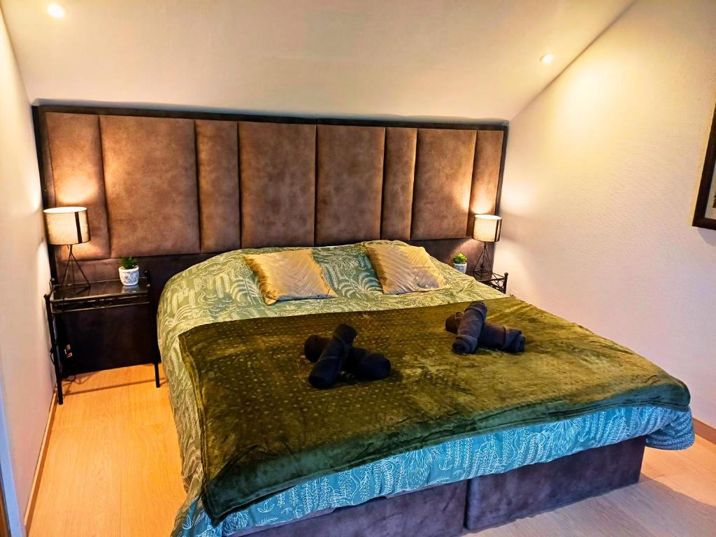 Un dormitorio con una cama grande con dos zapatos. en Le Beau Séjour 2 - Très Spacieux - Proche Aéroport en Beauvais