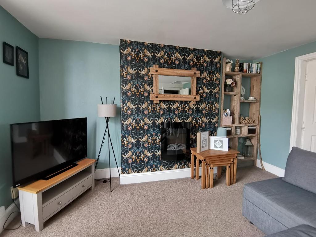 a living room with a flat screen tv and a couch at Driftwood Apartment in Saltburn-by-the-Sea