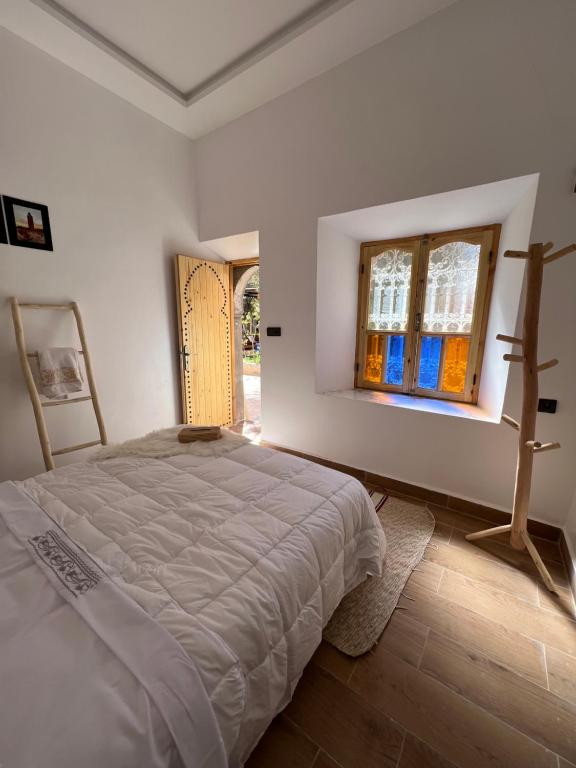 - une chambre blanche avec un lit et une fenêtre dans l'établissement Friendly Dades Lodge, 