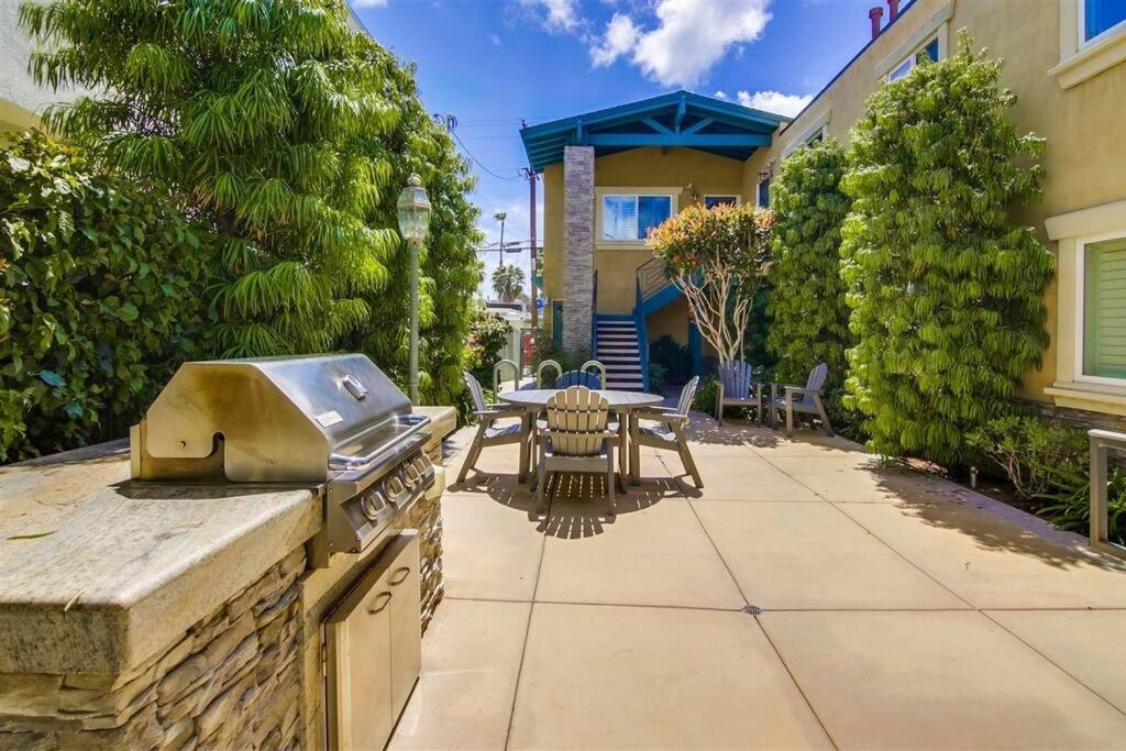 a outdoor patio with a grill and a table and chairs at Ocean Beach Pier Condo in San Diego