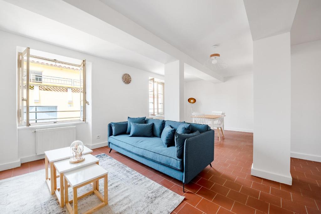 un salon avec un canapé bleu et une table dans l'établissement Les Colonnes - T3 - Bastide, à Carcassonne