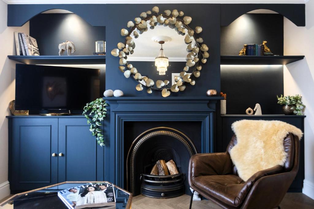 a living room with a fireplace and a mirror at Boutique luxury Stratford Townhouse- beautifully renovated sleeps upto 4 - free parking - minutes walk to theatres, town & pubs in Stratford-upon-Avon