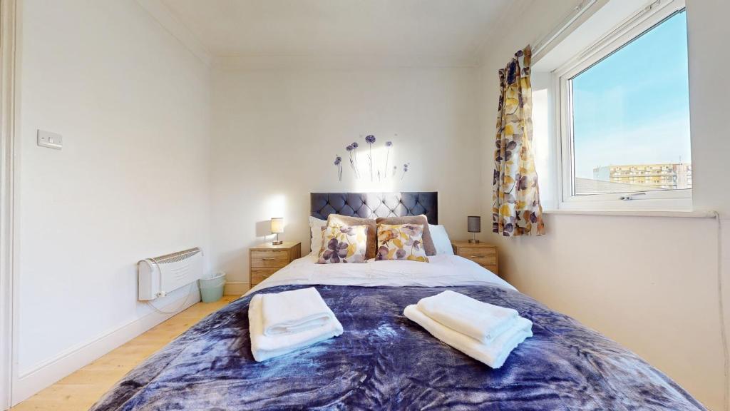 a bedroom with a large bed with two towels on it at The Cosy Bay Near Tower Bridge in London