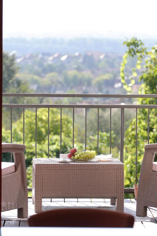 a table with a plate of grapes on a balcony at August Panorama Apartman in Vác
