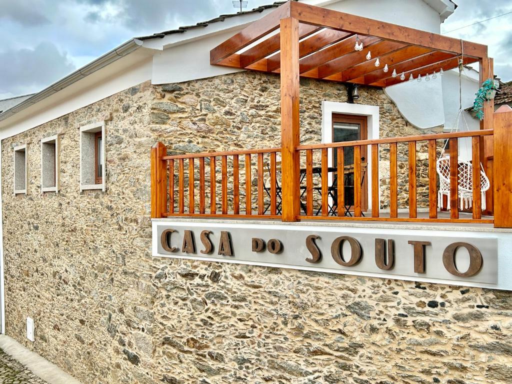 uma casa de pedra com um sinal ao lado dela em Casa do Souto - Nature & Experiences - Turismo Rural em Bragança