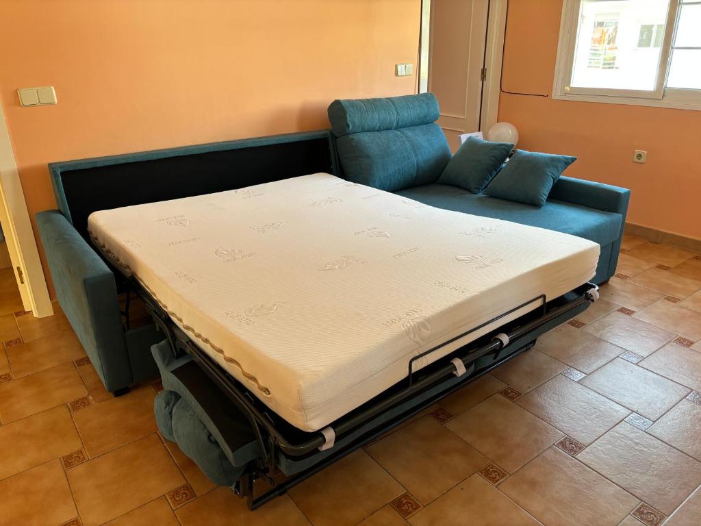 a bed sitting on top of a blue couch at Las Delicias de Estepona in Estepona