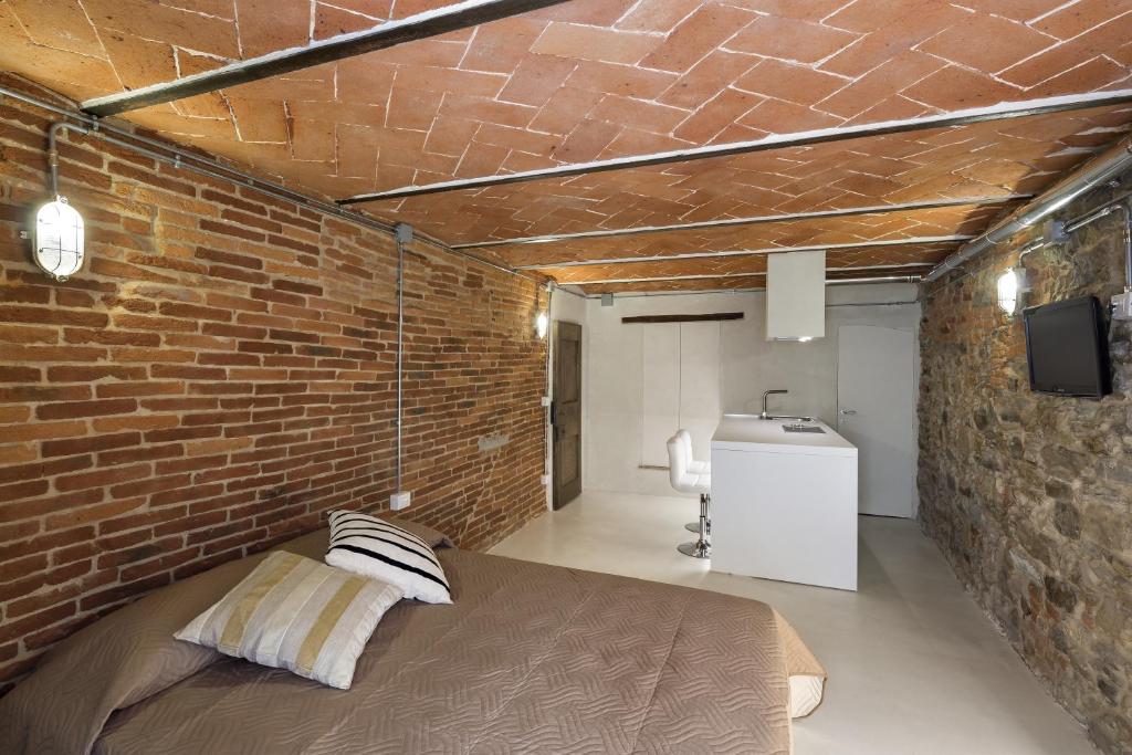 a brick wall with a bed in a room at Loft n°18 in Arezzo